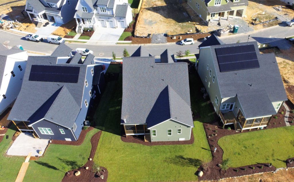 Neighborhood street with two homes with solar