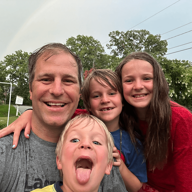 Graham Alexander with his family on a rainy day with a rainbow