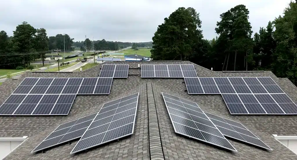 Aerial view of solar panels on a brown asphalt roof of a student housing building in Pembroke NC