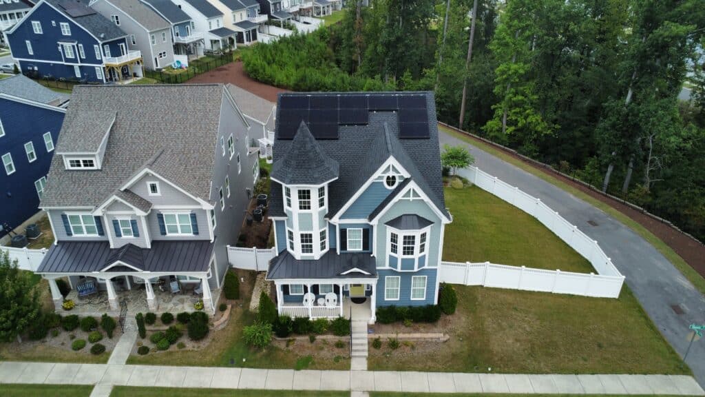 Modern Victorian style home with solar panels on roof. Photo taken from a drone above