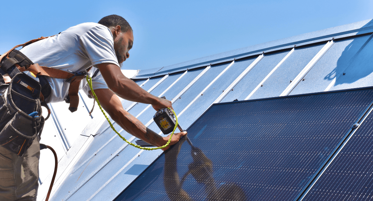 A solar installer from Southern Energy installs solar on a metal roof of a home