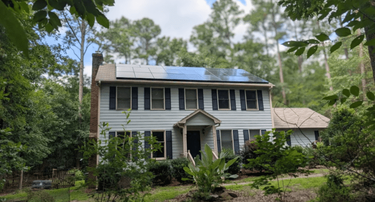 The front of a home in Chapel Hill, NC with lush greenery during a bright summer day with a rooftop solar installation