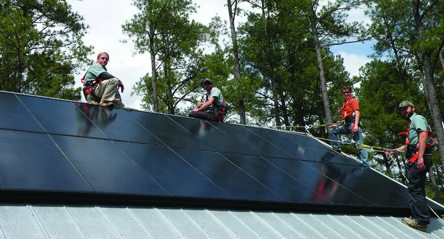 Southern Energy Management solar installers on a roof installing black panels