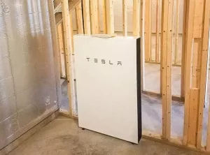 Tesla Powerwall mounted on framing in a basement