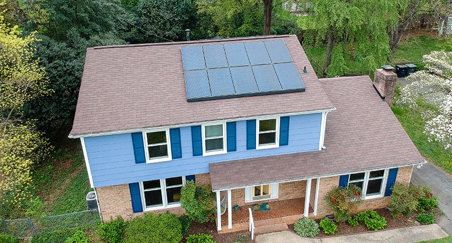 Blue two story home with a solar system on the roof