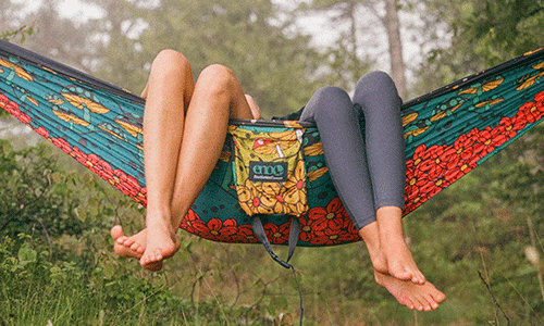 Two people hanging out in a colorful graphic print hammock by ENO