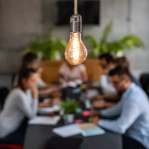 lightbulb hanging over a business team working at a table