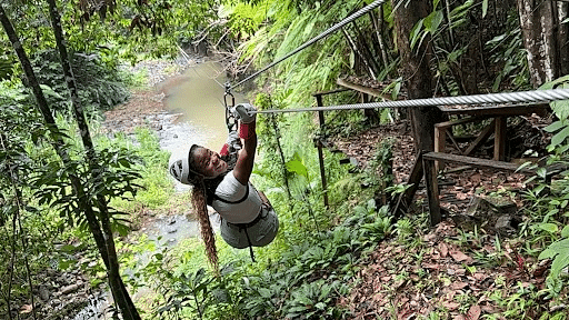 Carla, builder services coordinator at Southern Energy Management glides down a zip line in a forest