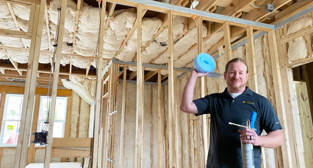 Matt, building performance expert, from Southern Energy Management holding sill seal and foam gasketing material on site for wall top air sealing