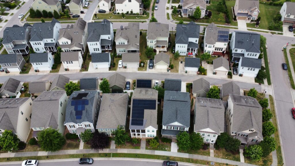 drone shot of a neighborhood with multiple solar installations on roof