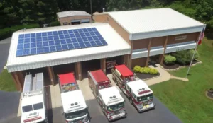 Aerial view of Durham Highway Fire Department with a rooftop solar panel system installed by Southern Energy Management in NC. Five fire trucks are parked in front of the building