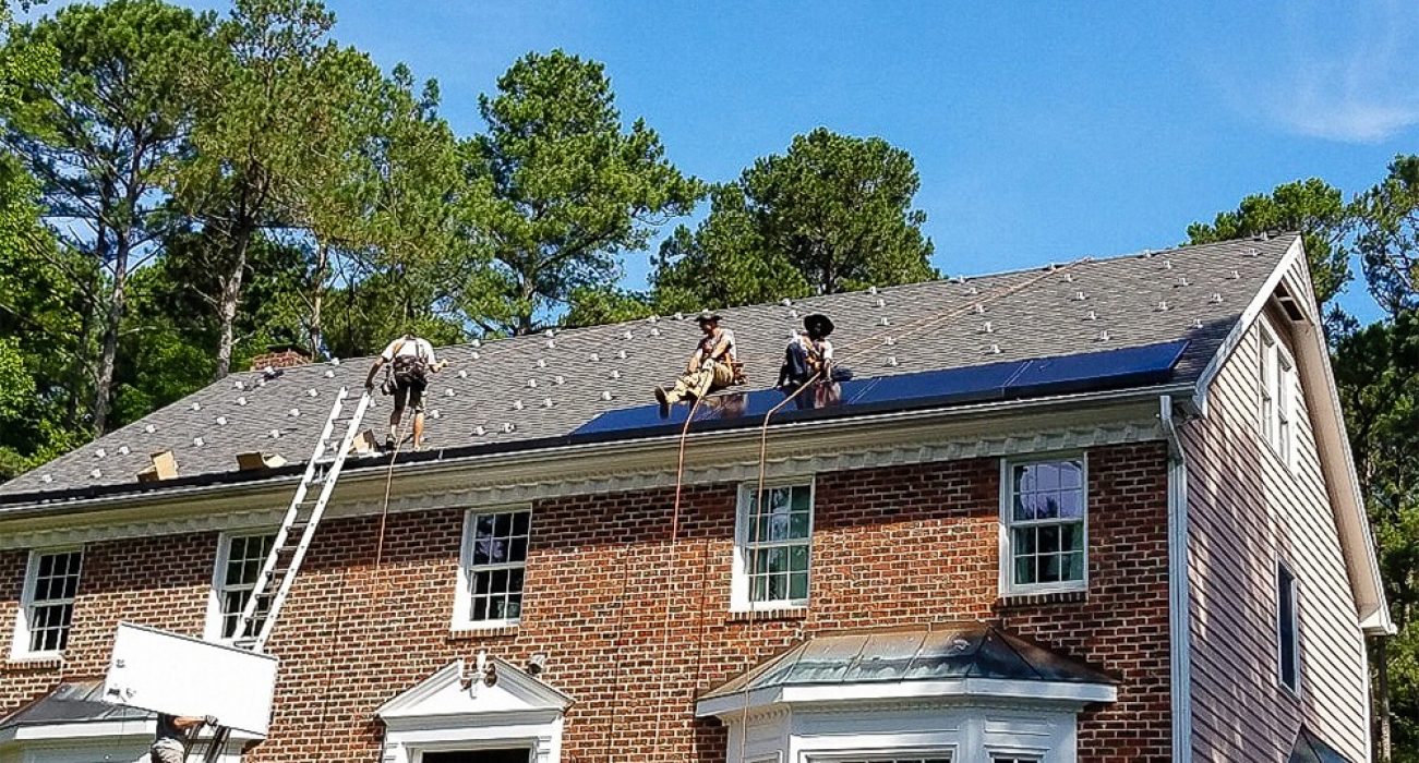 Solar being installed on a colonial brick home's roof