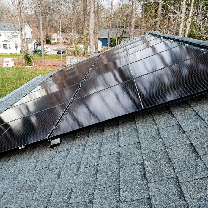 Roof mounted solar panels installed on a gray shingled roof