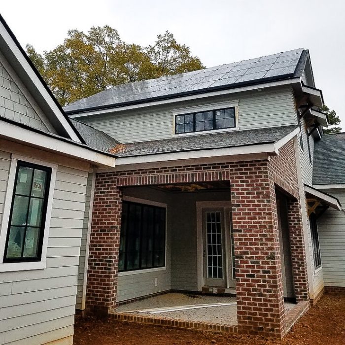 View from ground level of a monochrome pv solar system on a new construction home