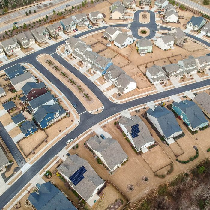 Aerial view of new construction neighborhood with two homes that have solar systems