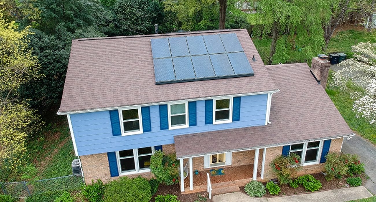 Blue two story home with a solar system on the roof