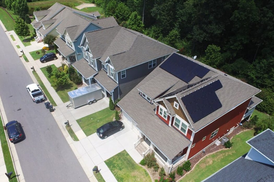 Aerial view of a black roof solar system on a red house