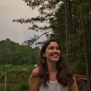 Emma in the great outdoors with a rainbow in the distance