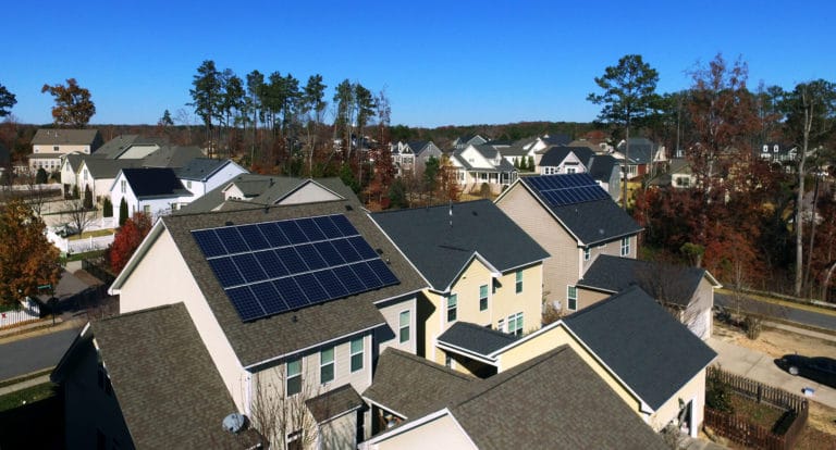 Two neighboring homes with rooftop solar systems on the same street