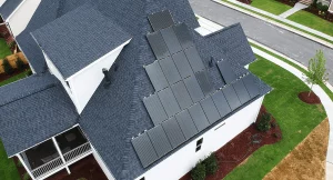 Aerial view of a home with black solar panels on the roof