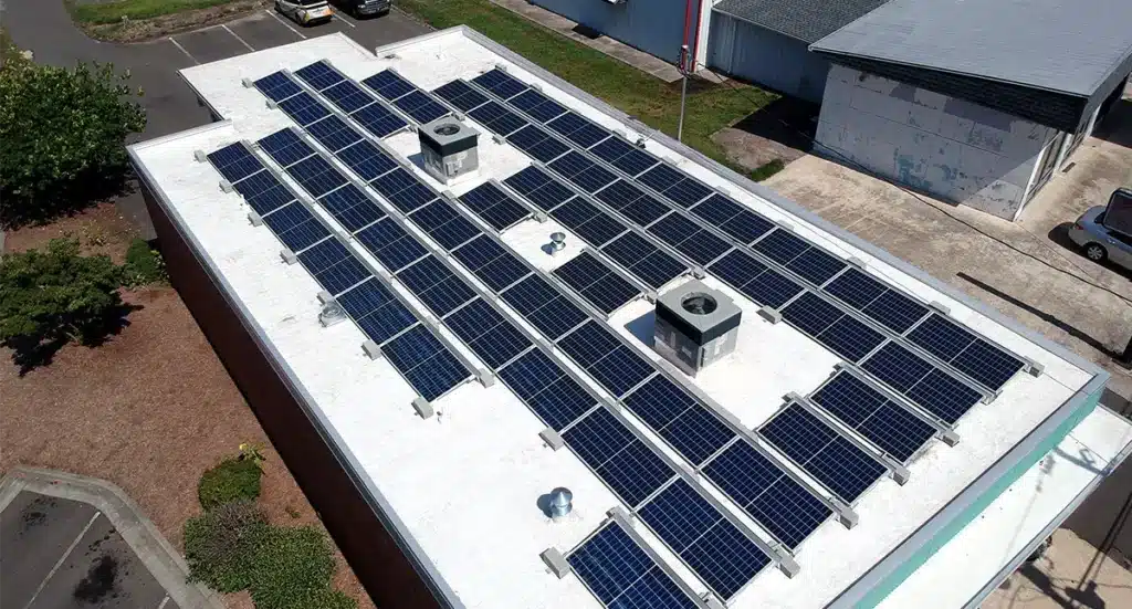 Aerial view of solar panels installed on a flat white roof of a commercial building in North Carolina