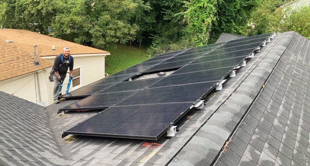 Solar installer on a roof with a home solar system