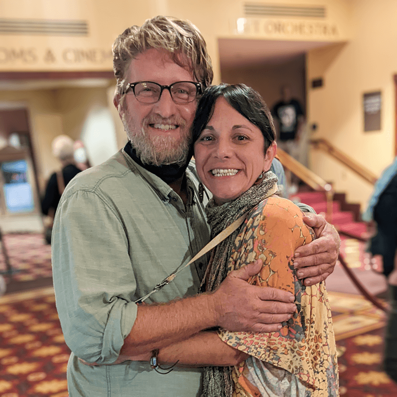 Jamie with her partner, Ryan, smiling together at a concert hall