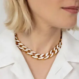 Woman with short blonde hair wearing a chunky gold necklace by Joanna Laura Constantine