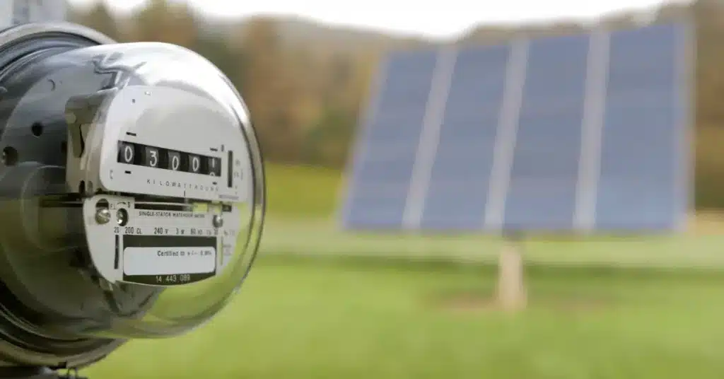 an electric meter with a ground mount solar system behind