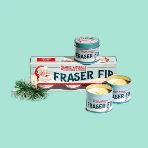 trio of santa's naturals fraser fir candles sitting on a product box