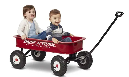 Two children in a red Radio Flyer Wagon