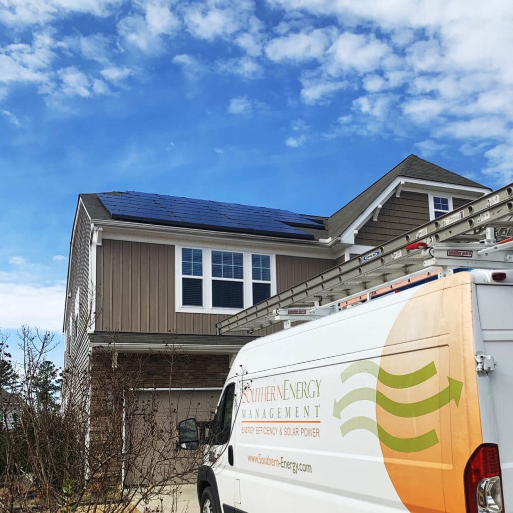 SEM Install truck in front of a home with roof mounted solar and blue skies
