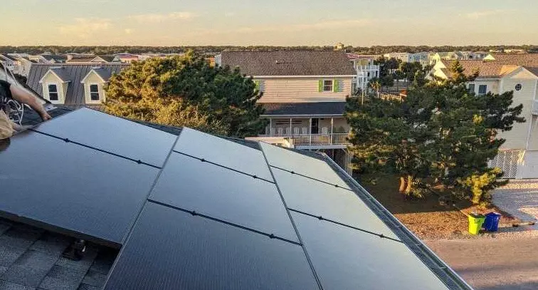 Rooftop view of a roof mounted solar system with a sunset in the background