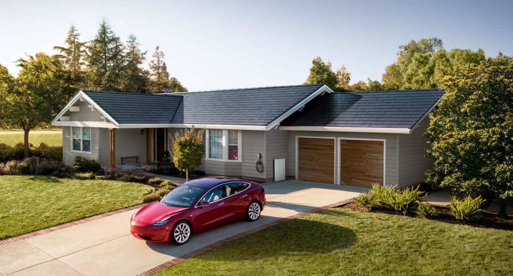 Tesla solar shingle roof with a powerwall system on a one story home with a Tesla electric vehicle in the driveway